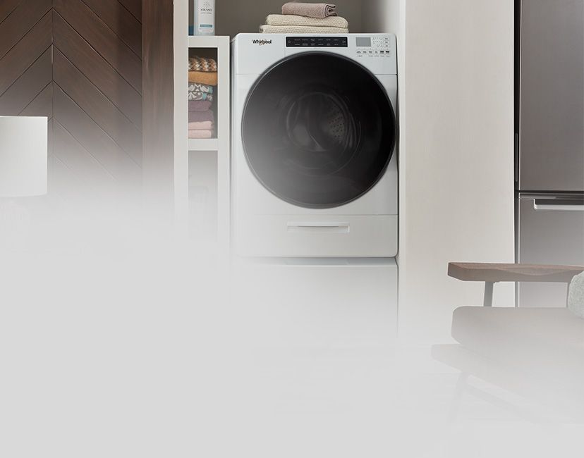 À côté d'une cuisine se trouve une salle de lavage avec une sécheuse à chargement frontal Whirlpool